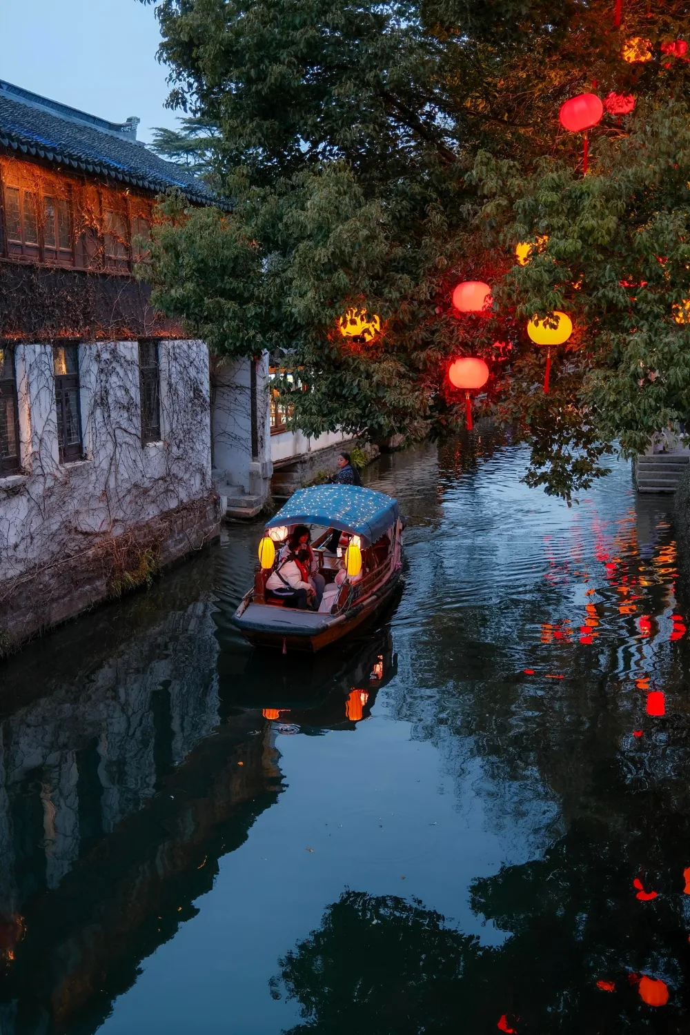 苏州河道夜景，画舫红灯笼与树灯倒影